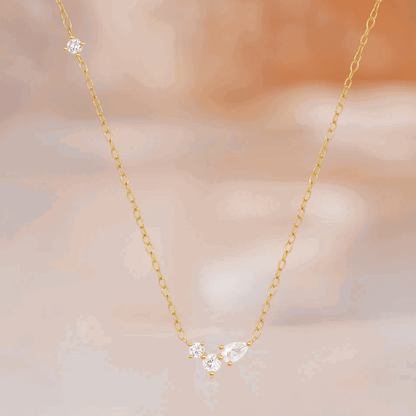Gold-tone delicate necklace featuring three round and one pear cubic zirconia stones