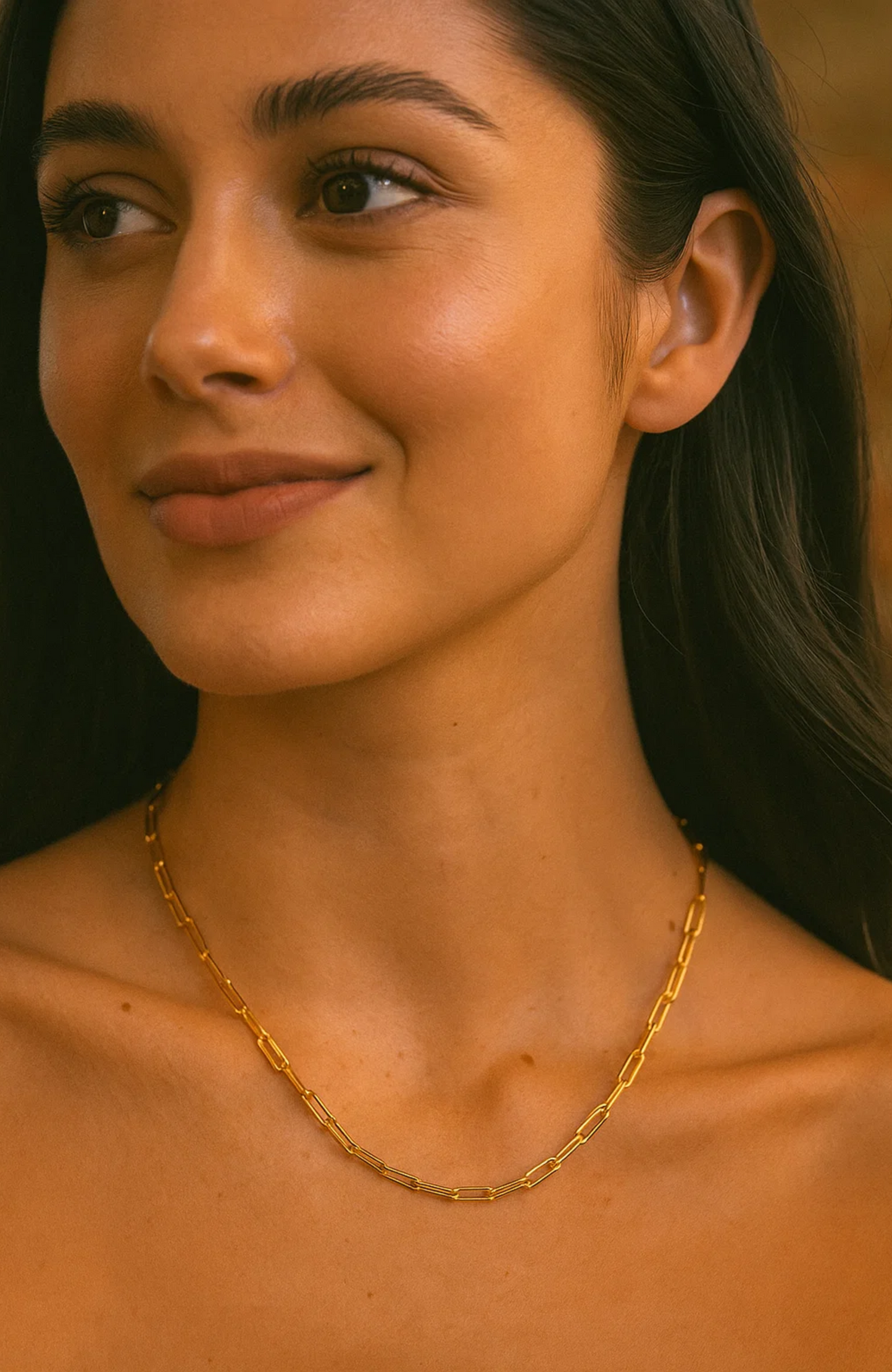 Gold paperclip-link necklace worn around the neck with linked metal segments