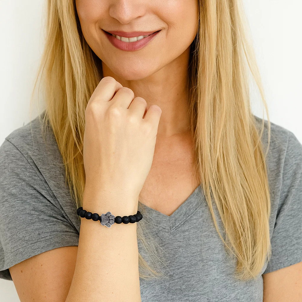 Black bead bracelet with silver paw charm on wrist