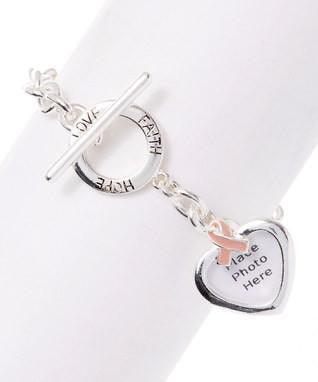 Pink beaded bracelet close-up with heart charm and silver clasp