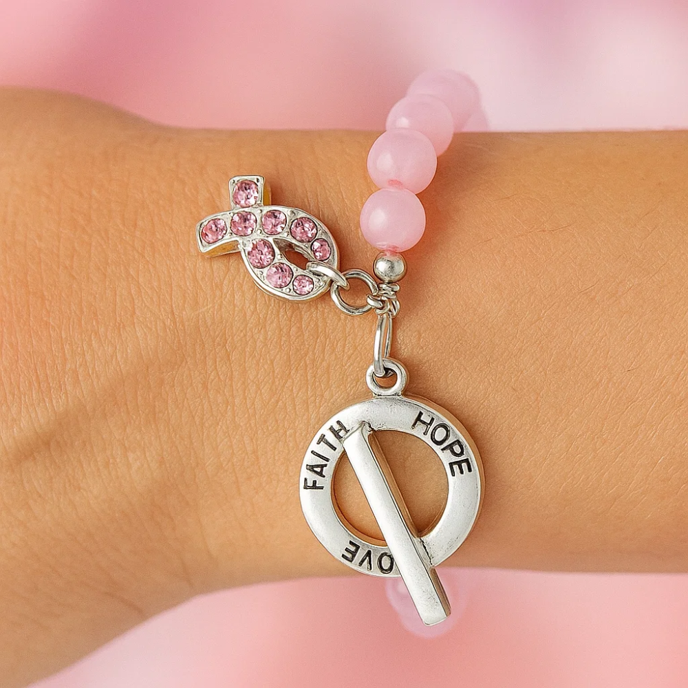 Pink beaded bracelet on wrist with rhinestone ribbon and faith/hope charms