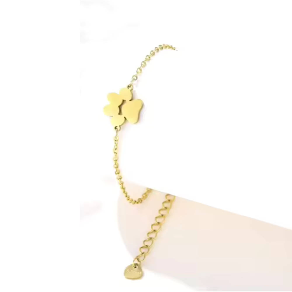 Gold link chain paw cutout charm bracelet with dangling paw charm and small tag charm