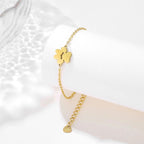 Gold link chain paw cutout charm bracelet with large paw charm and small disc charm