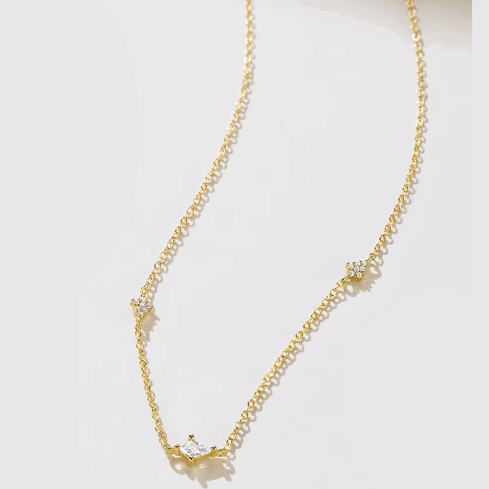 Gold-tone starburst necklace with clear crystal center on fine link chain