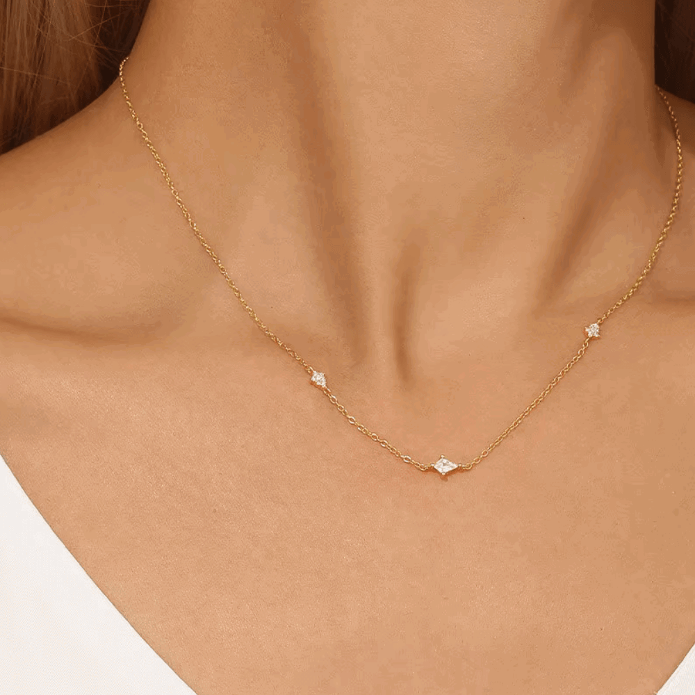 Gold-tone starburst necklace with small clear crystal center on delicate chain