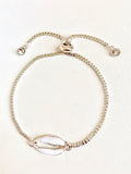Silver seashell charm bracelet with spring clasp and small round crystal accents.