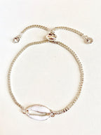 Silver seashell charm bracelet with spring clasp and small round crystal accents.