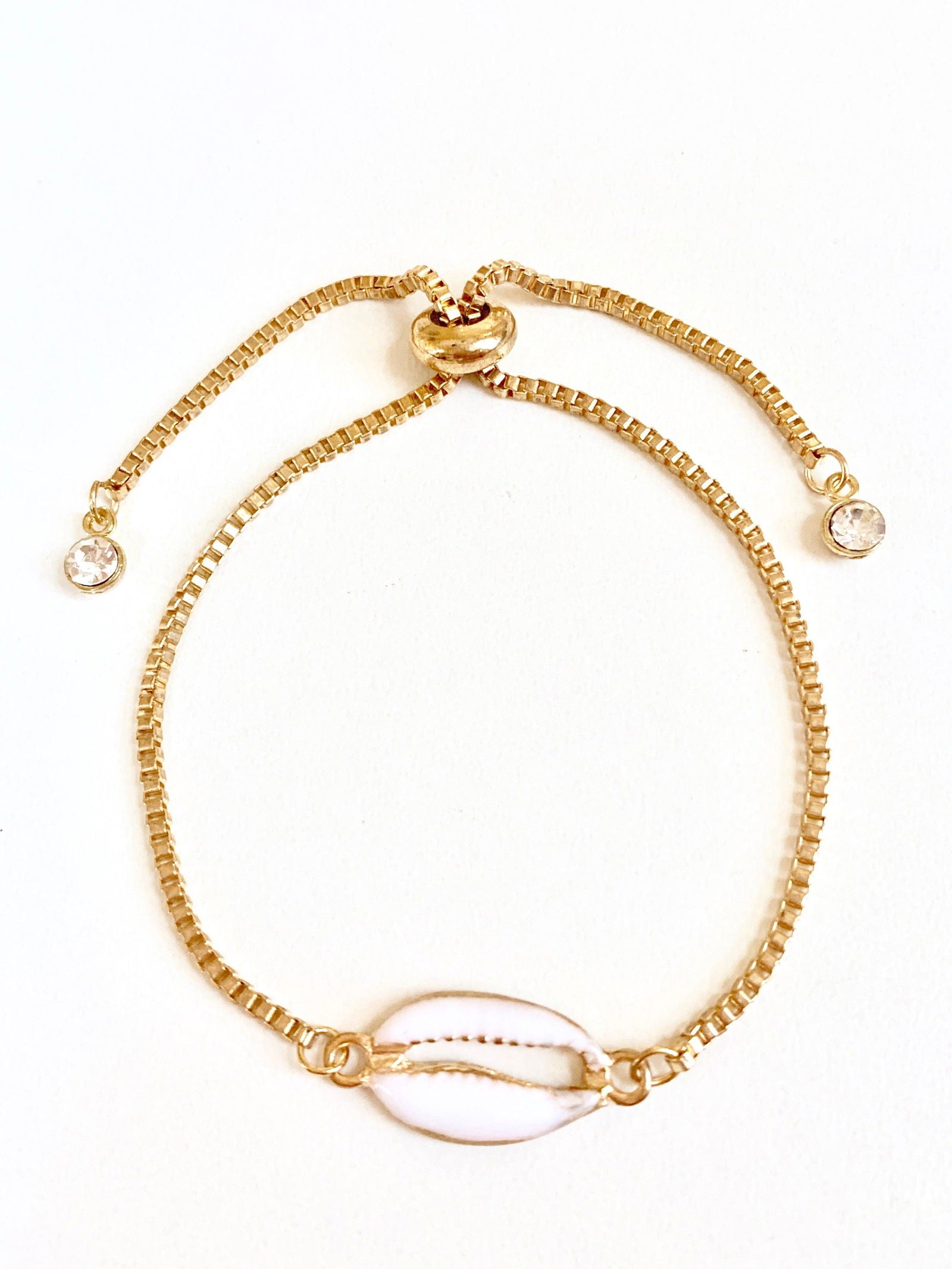 Gold seashell bracelet with oval shell charm, beaded links, and side crystal beads