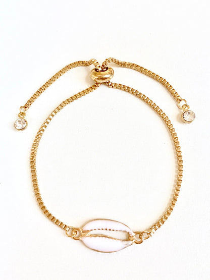 Gold seashell bracelet with oval shell charm, beaded links, and side crystal beads