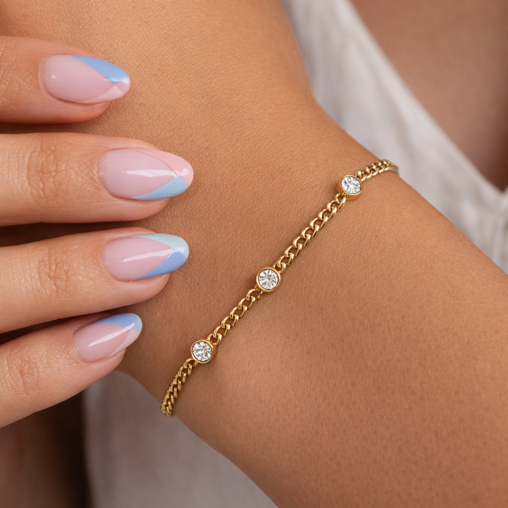 Gold bezel link bracelet with round clear stones on a chain of links