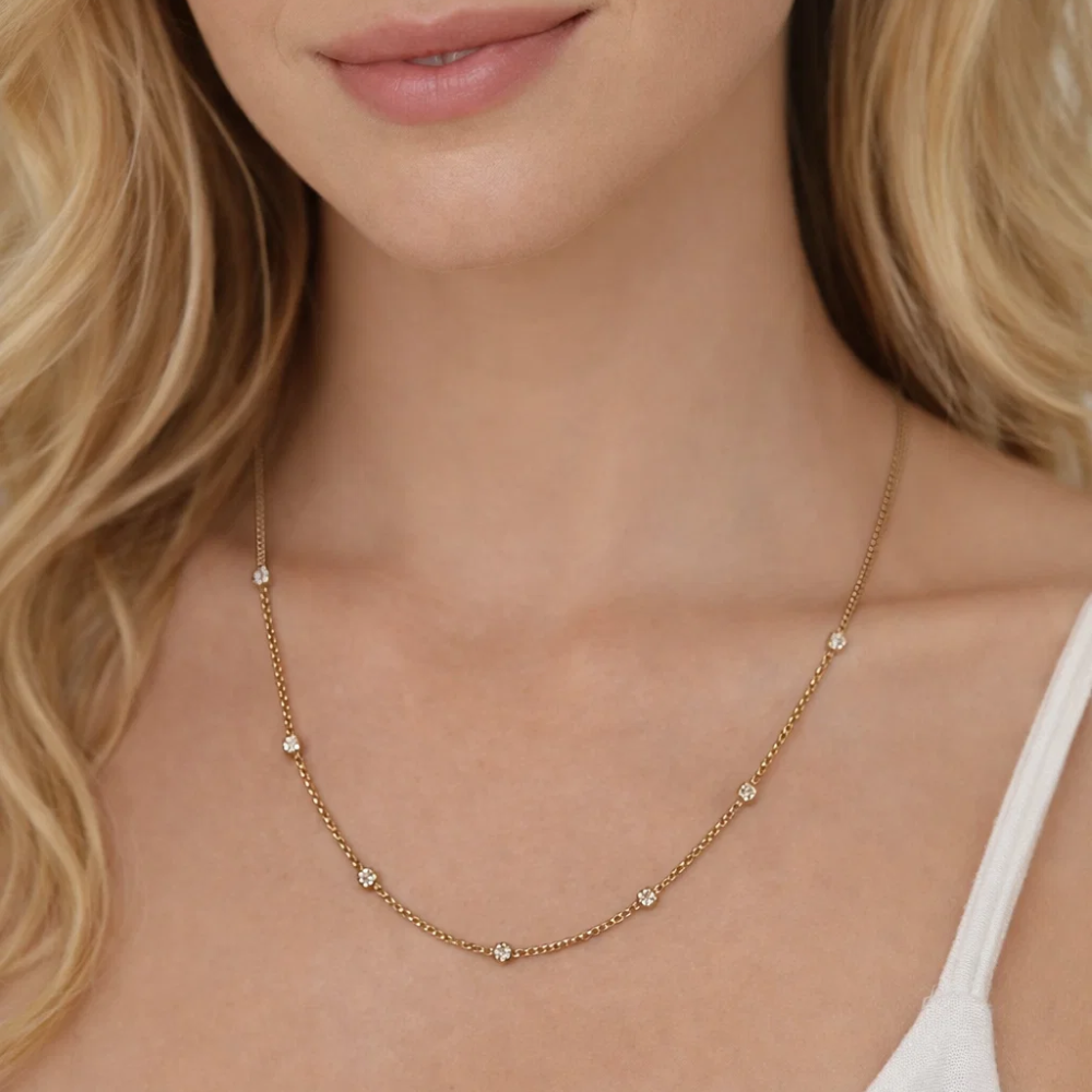 Close-up of gold bezel link necklace with round stones along chain