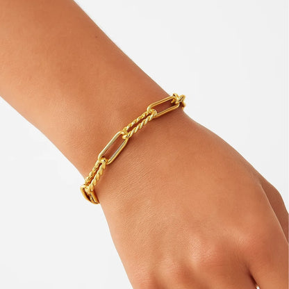 Gold paperclip chain bracelet on wrist with interlocking bar links