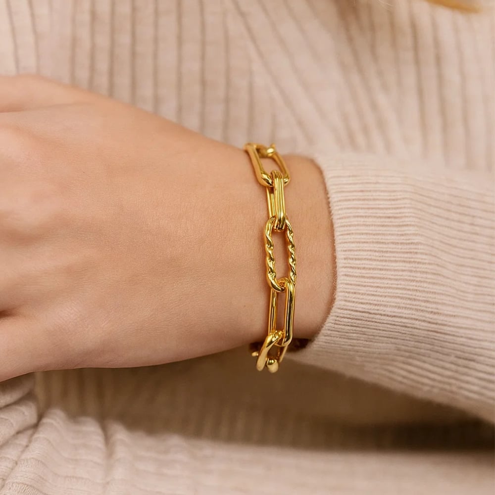 Gold paperclip chain bracelet with adjustable link bar and clasp on wrist