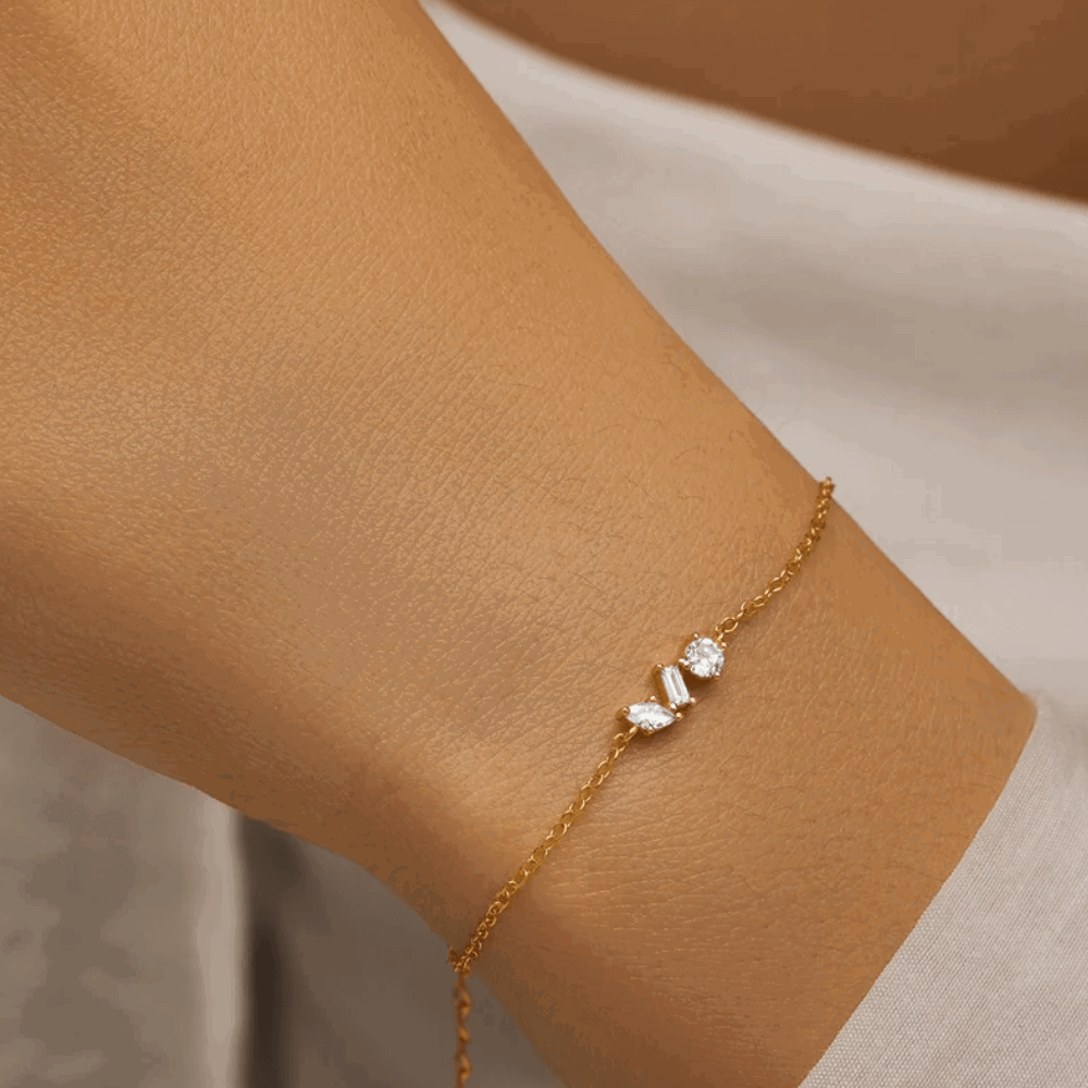 Gold chain bracelet on wrist with small cubic zirconia square and round stones