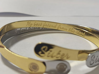 Gold sister bracelet close-up showing engraved inside text and oval face