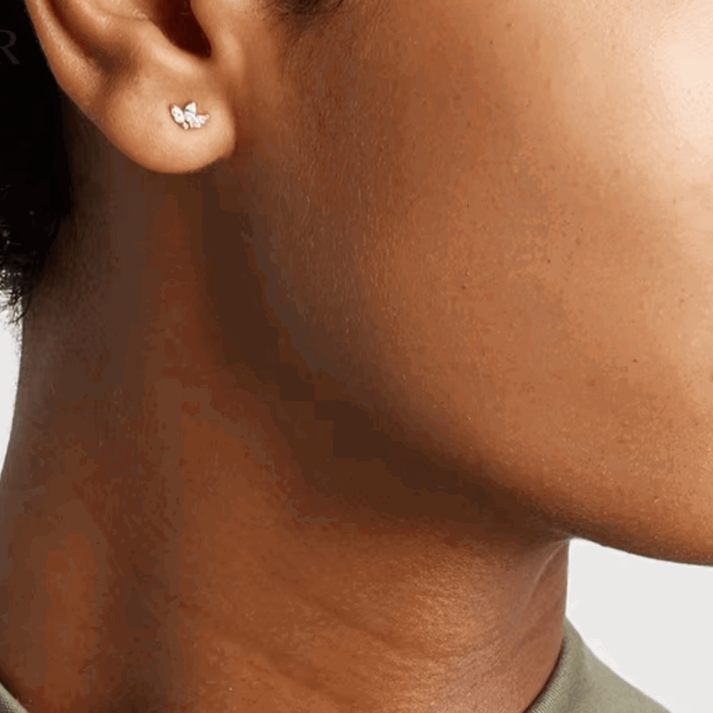 Small flower stud earrings with cubic zirconia center on ear