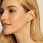 Gold-tone teardrop hook earrings on model, angled side view