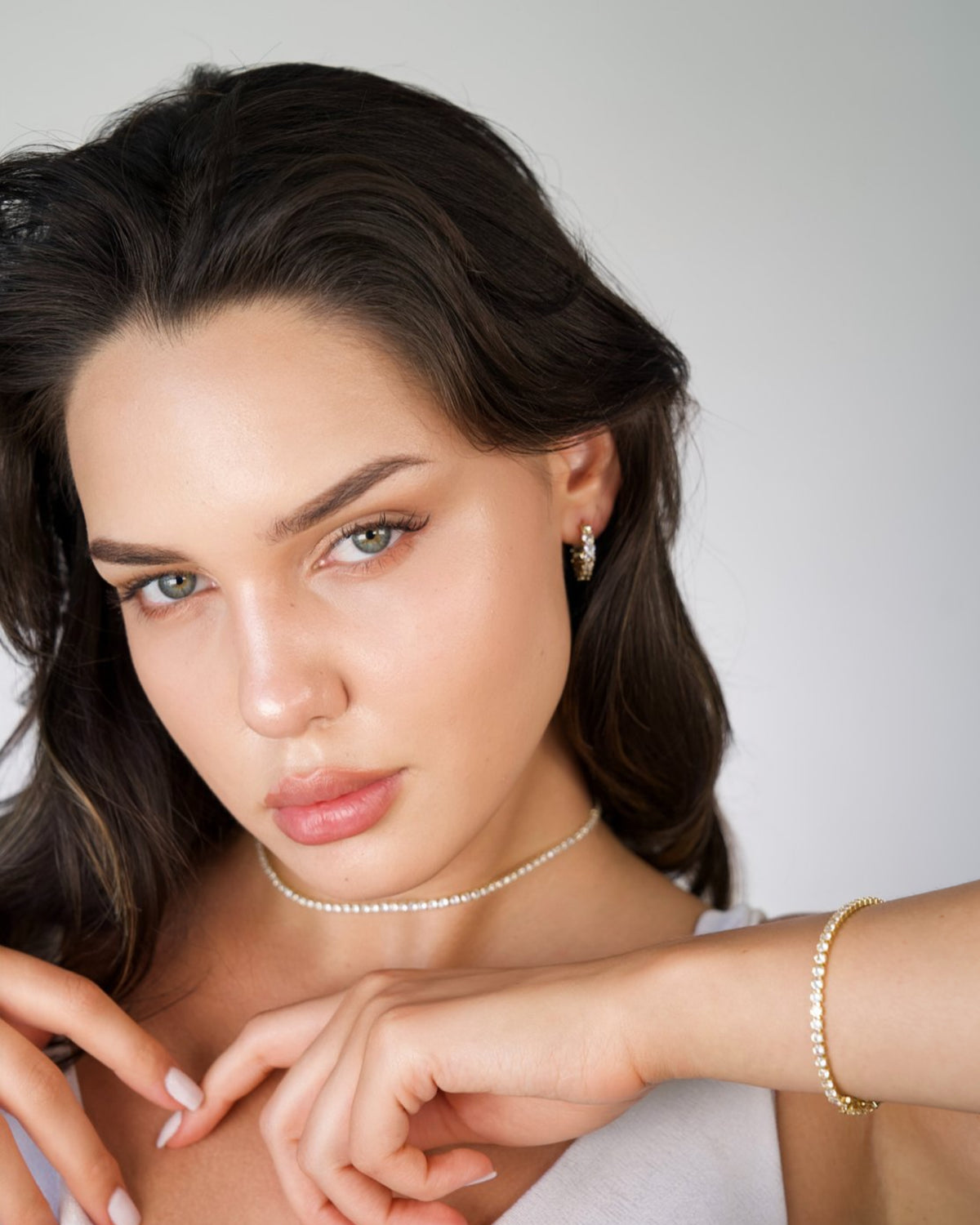 Silver tennis bracelet with cubic zirconia stones, worn on model’s wrist