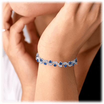 Sapphire blue tennis bracelet worn on wrist with round stones and clear diamond-like accents