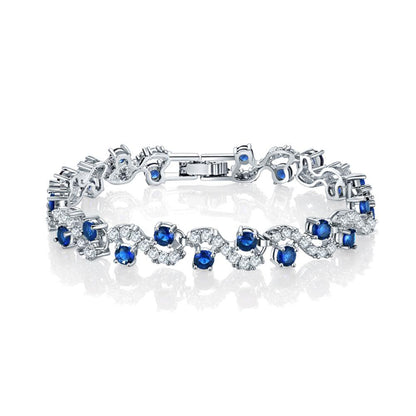 Sapphire blue round-stone tennis bracelet with clear accents, silver-tone links