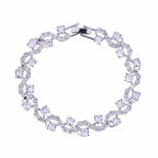 Round-cut cubic zirconia tennis bracelet in silver-tone, flexible oval link design.