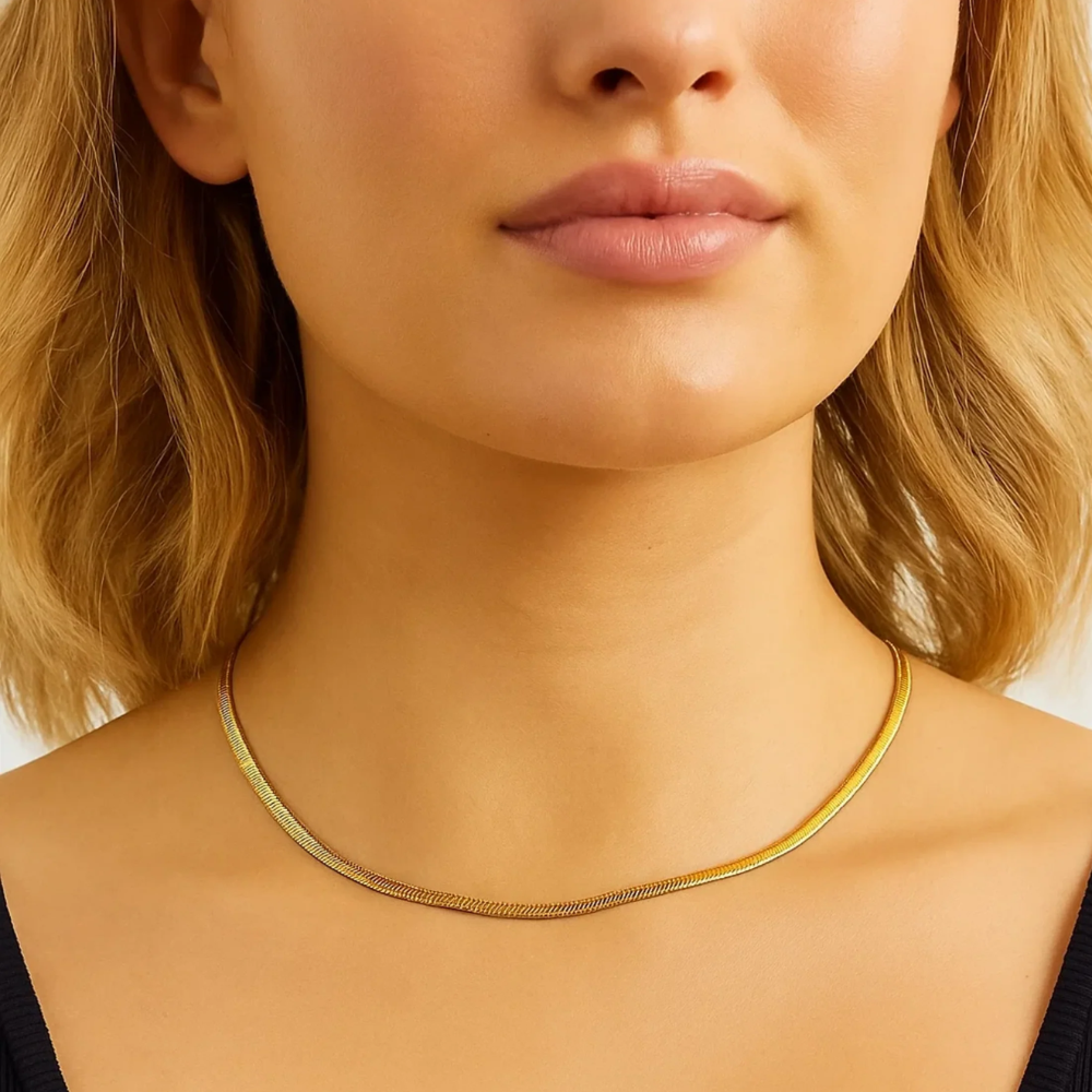 Gold snake chain necklace on model, thin coil-like links