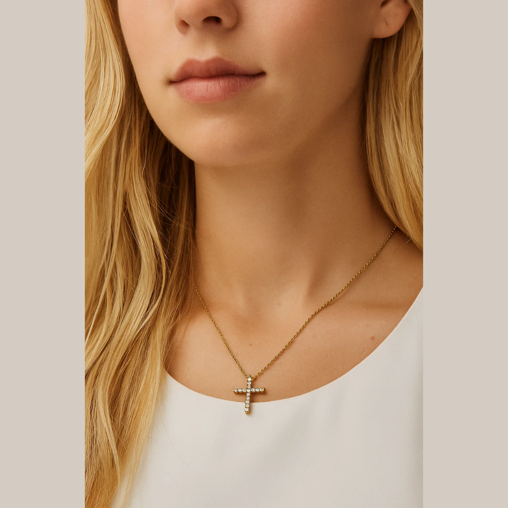 Gold-tone cross pendant necklace with clear CZ stones, worn with blonde hair