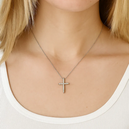 Silver-tone cross pendant necklace with clear CZ stones, worn on neckline