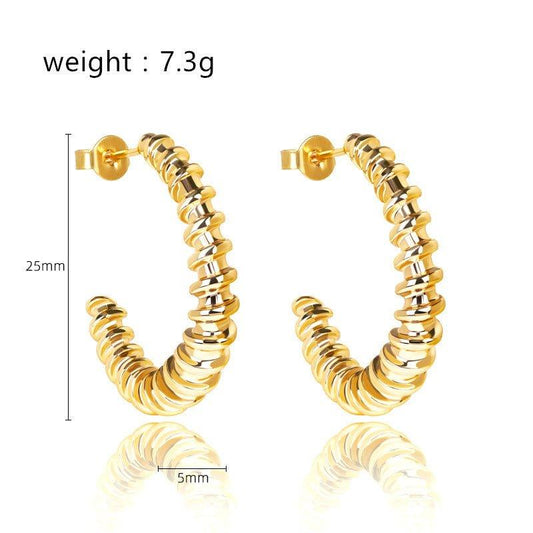 Gold twist hoop earrings with spiral ridges, glossy finish, and ball post