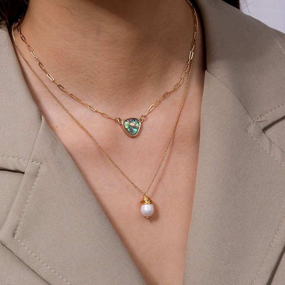 Two-layer necklace worn on neck: abalone heart pendant and pearl drop