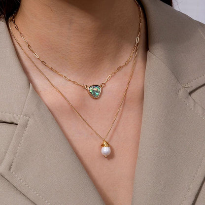 Two-layer necklace worn on neck: abalone heart pendant and pearl drop