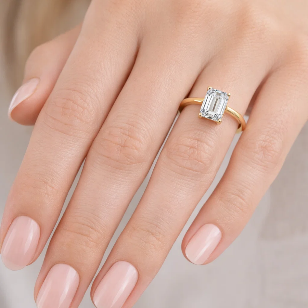 Gold vermeil emerald-cut solitaire ring with rectangular step-cut stone, top view on fingers