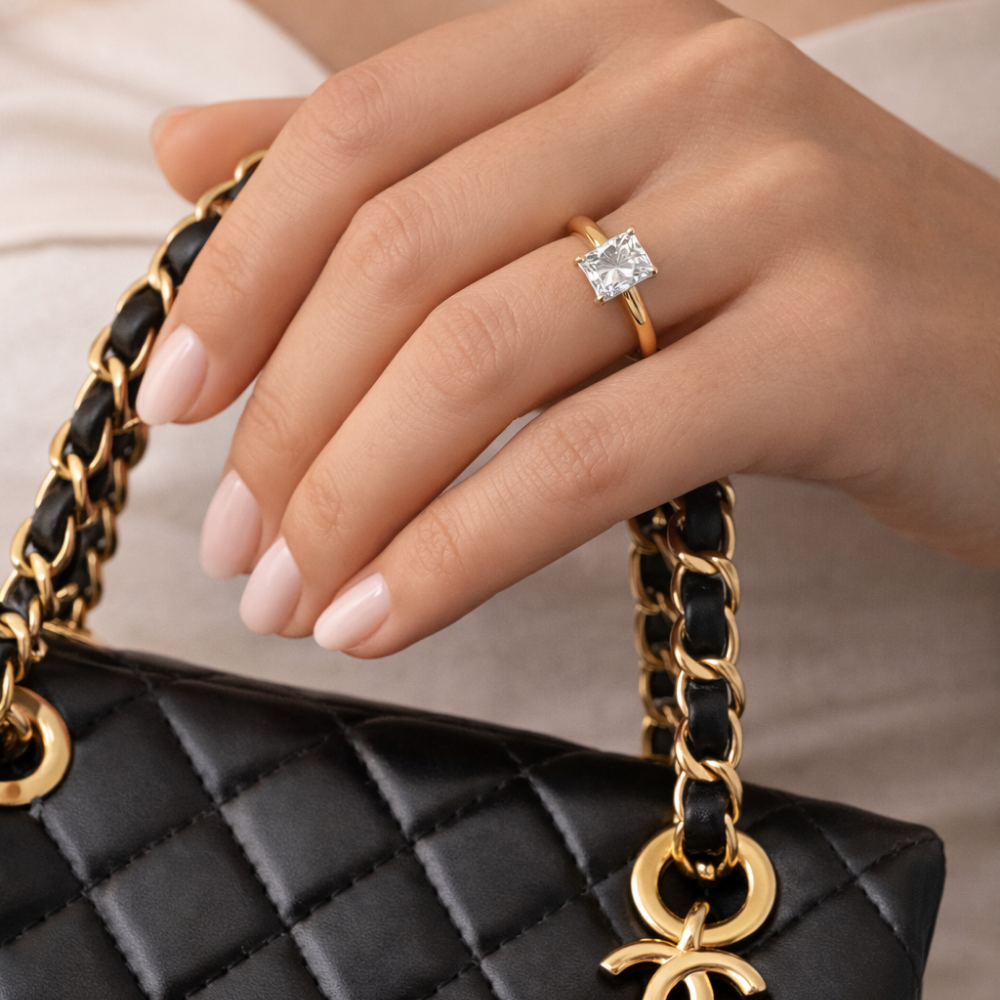 Gold vermeil emerald-cut solitaire ring with prongs, worn on hand