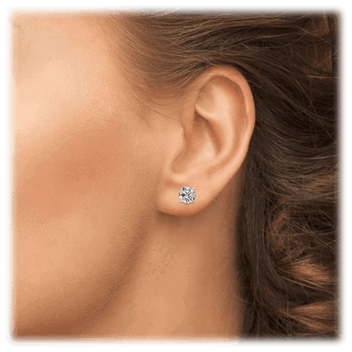 Small round cubic zirconia stud earrings on ear, silver-tone setting