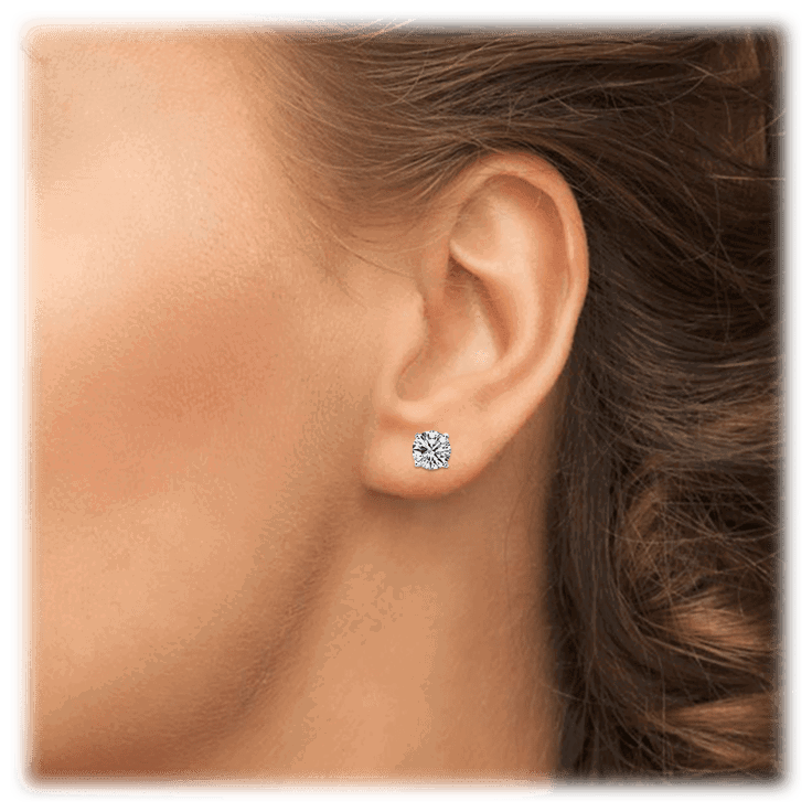 Small round cubic zirconia stud earrings on ear, silver-tone setting