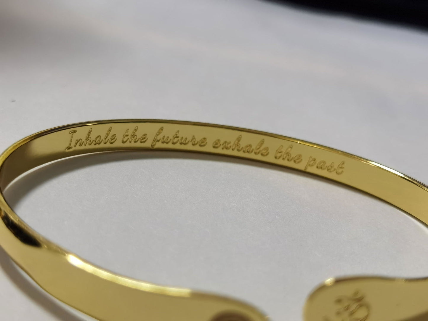 Gold yoga bracelet with engraved inner lettering along the band