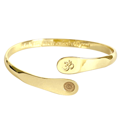 Gold yoga bracelet with raised Om engraving and two round stamped discs