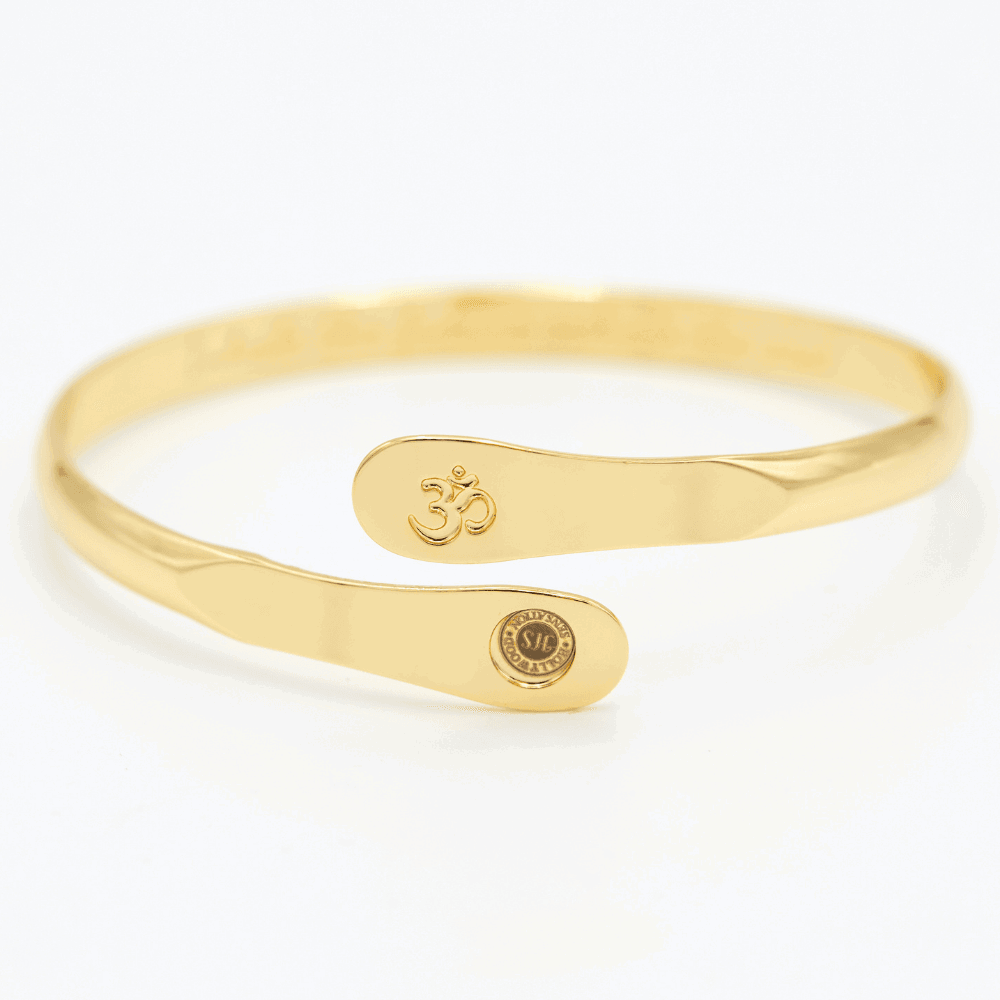 Gold yoga bracelet with engraved Om symbol plate and small round logo on side