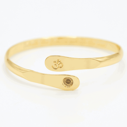 Gold yoga bracelet with engraved Om symbol plate and small round logo on side