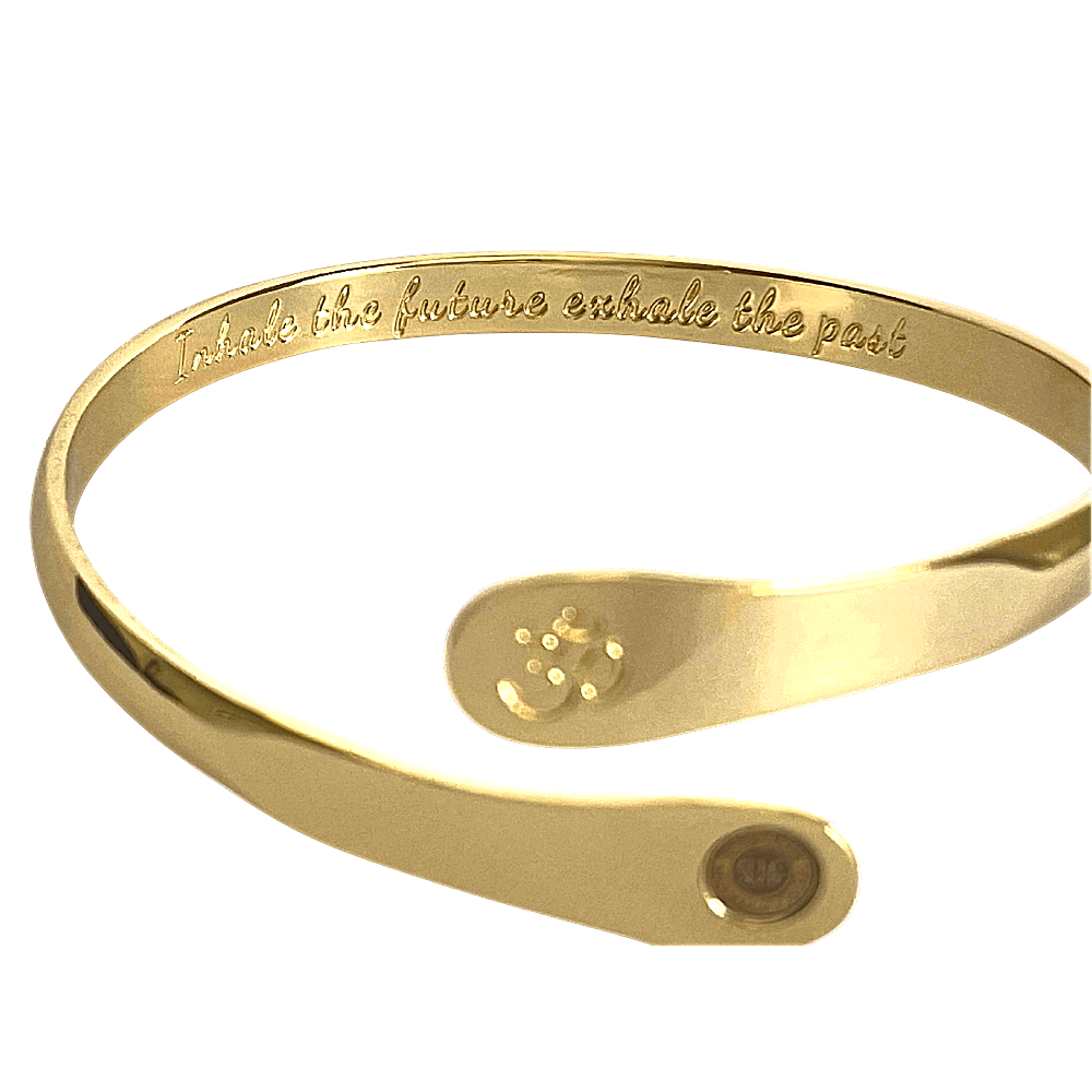 Gold yoga bracelet with engraved inner text, Om symbol plate, and round logo on side