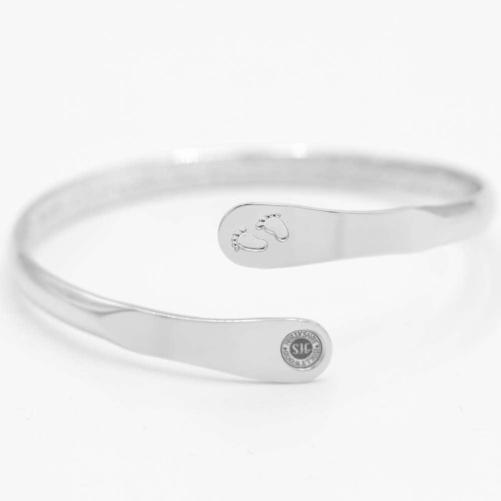 Silver baby footprint engraved bangle bracelet with circular hallmark on cuff end