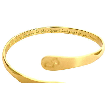 Gold baby footprint engraved bangle bracelet with small oval footprint charm at center.