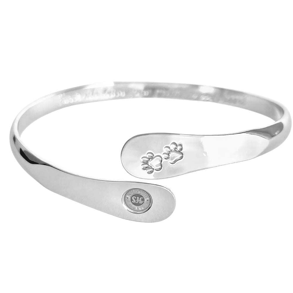 Silver paw print cuff bracelet showing inner paw engraving and oval logo medallion