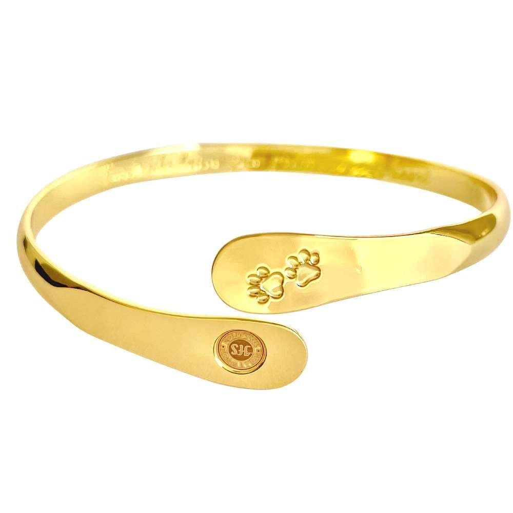 Gold paw print cuff bracelet showing inner paw engraving and oval logo medallion