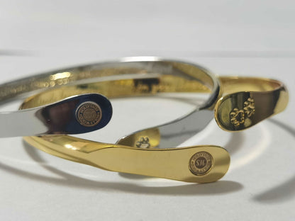 Gold and silver cuff bracelets with oval medallion and paw print details