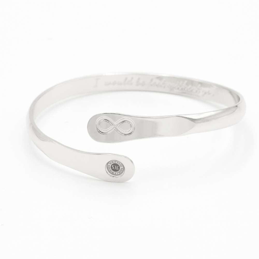 Silver infinity friendship bracelet on a flat surface, engraved infinity emblem and round logo tag.