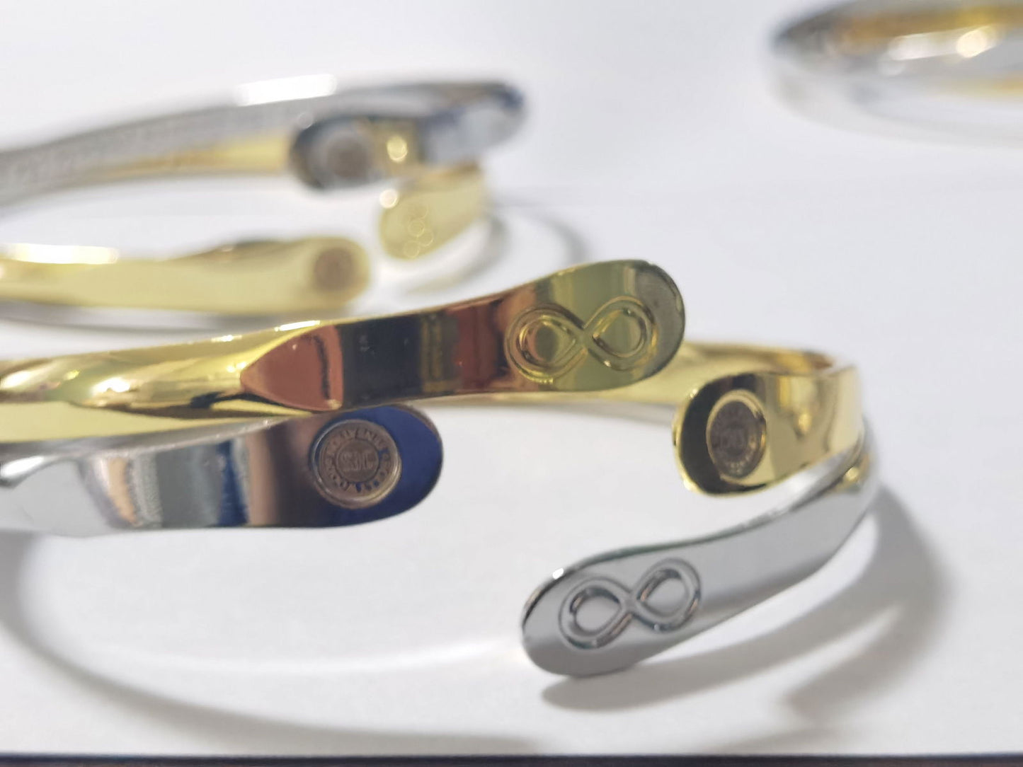 Infinity friendship bracelet set, silver and gold bands with engraved infinity symbols and charms.