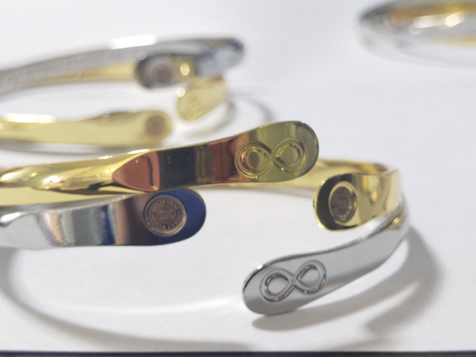 Infinity friendship bracelet set, silver and gold bands with engraved infinity symbols and charms.