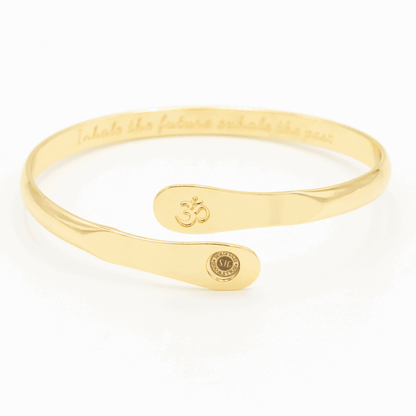 Gold yoga bracelet with engraved Om symbol plate and small round logo on side